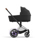 Cybex e-Priam Seitenansicht mit adaptiver Schiebehilfe und elegantem Rahmendesign.
Rahmen in Chrome with Black Details und der Carry Cot in Sepia Black