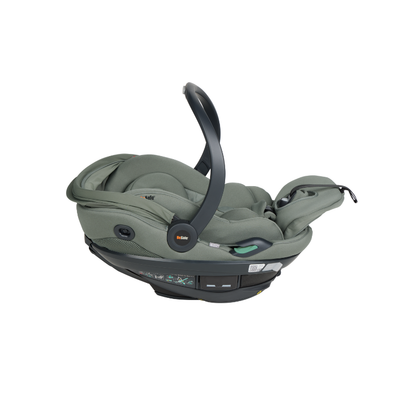 Grüne Babyschale mit Tragegriff, gepolsterter Liegefläche und integriertem Gurtsystem in schräger Seitenansicht.erweiterte Liegefläche.