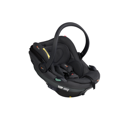 Schwarze Babyschale mit Tragegriff, gepolsterter Liegefläche und integriertem Gurtsystem in schräger Seitenansicht.