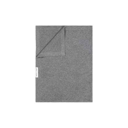 echteckige Decke aus Stoff in Graue Farbe, eine Ecke leicht umgeschlagen, mit kleinem seitlichem Etikett.