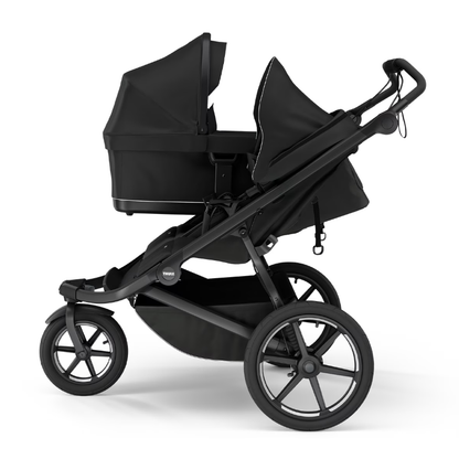 Thule Urban Glide 3 Kinderwagen mit Babywanne in Schwarz – seitliche Ansicht des Kombikinderwagens mit Neugeborenenwanne und Sportsitz für maximale Flexibilität von Geburt an