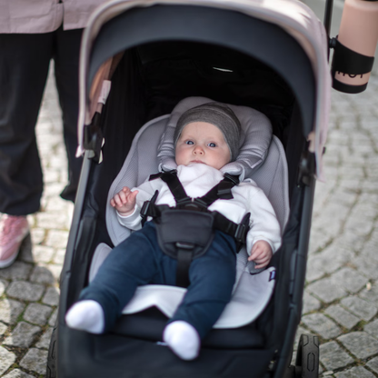 Baby im Thule Kinderwagen mit gepolstertem Neugeboreneneinsatz und sicherem 5-Punkt-Gurt-System